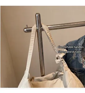 Close-up of the comfortable cream tote bag handles and side bow detail on a hanger