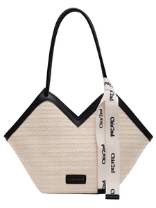 Large woven straw beach tote bag with black leather straps and V-shaped top design