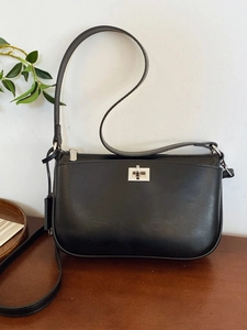 Minimalist black leather crossbody bag with silver twist lock and shoulder strap