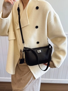 Classic black leather crossbody flap bag for women styled with a beige winter wool coat