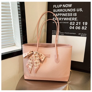 Detail view of pink woven tote bag with leather piping and a houndstooth scarf ribbon bow