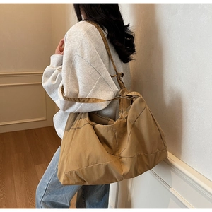 Detailed shoulder view of the large tan tote bag with soft pleated nylon design
