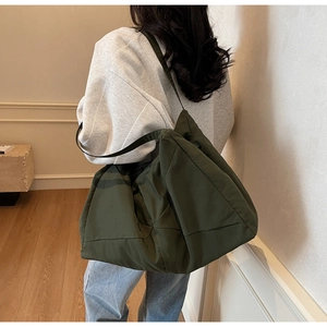 Rear view of a stylish olive green nylon tote bag with wide shoulder straps for women