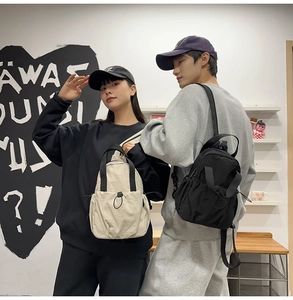 Lifestyle shot of lightweight drawstring backpacks in cream and black on models