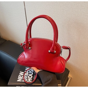 Detail of red glossy shell bag with silver hardware and chic double round handles