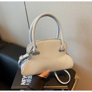 Detail of light blue shell-shaped handbag with silver hardware and smooth leather texture