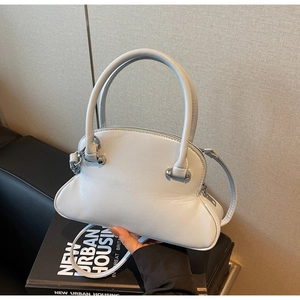 Close-up of a light blue leather shell bag with round handles and silver hardware detail