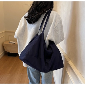 Macro shot of durable deep blue tote bag with wide shoulder strap for commuters