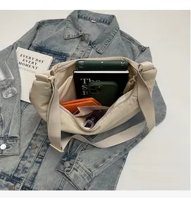 Spacious interior of beige crescent dumpling bag holding a tablet and daily essentials