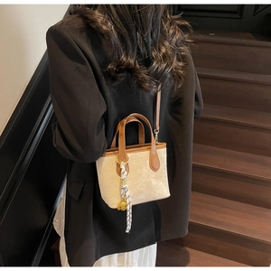 Model view of stylish beige bucket bag with star jacquard and brown leather details