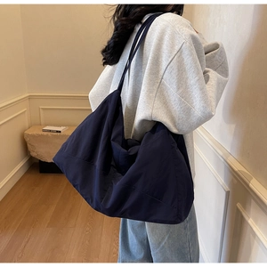 Deep blue oversized tote bag in soft fabric being worn, ideal for daily school commute