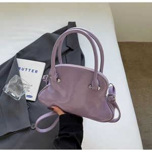 Close-up of a stylish lavender seashell bag featuring glossy finish and silver hardware