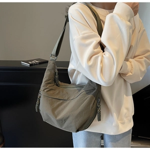 Detail of olive green crescent crossbody bag with adjustable wide strap and textured nylon