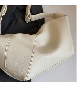 Close-up of soft lychee grain PU leather with vertical stitching on beige tote bag