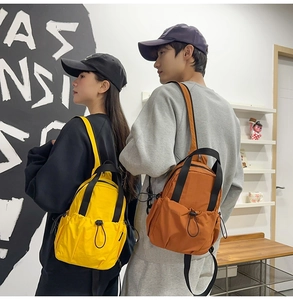 Mini nylon backpack in yellow and caramel orange colors shown with outdoor styling