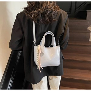 Dettaglio borsa a secchiello grigio chiaro in vernice con logo NICH NICH e ciondolo