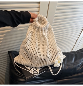 Primer plano detallado de un bolso de ganchillo blanco con detalles florales tejidos