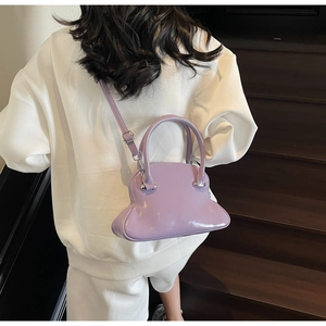 Detail of light purple glossy shell bag with silver metal buckles and sleek strap