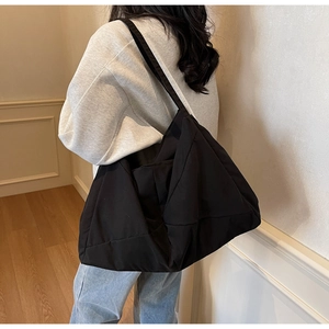 Rear view of a black canvas tote bag showing its large capacity and minimalist design