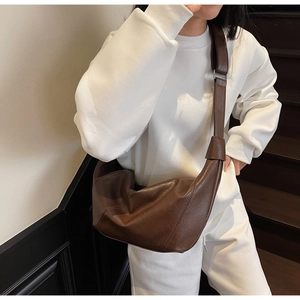 Detail of adjustable strap and stitching on brown soft leather hobo crossbody bag