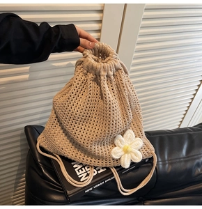 Detalle de bolso de ganchillo beige con cordón y decoraciones florales de margaritas
