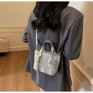 Silver bucket bag with star and butterfly embossing shown on model for scale