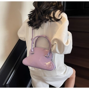 Side view of a light purple glossy shell bag with cloud-shaped base on a female model