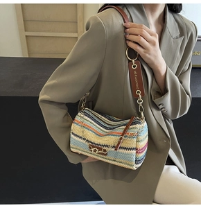 Detail of bohemian striped woven bag with brown leather strap and floral gold chain