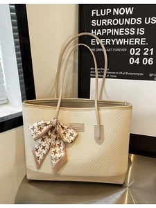 Minimalist beige woven tote bag with faux leather handles and houndstooth bow accessory