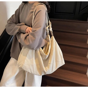 Chic beige oversized tote bag with knot strap detail shown on model for daily commute