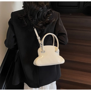 Chic cream white shell-shaped shoulder bag shown on a model against a dark background