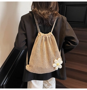 Detalle de la mochila de ganchillo beige con flor de margarita 3D sobre malla tejida
