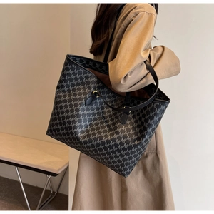 Detail of gray monogram tote bag with MK print styled with khaki coat for commute