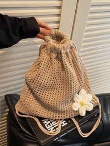 Mochila de paja tejida a mano con detalle de margarita y cierre de cordón para playa