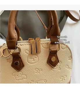 Detail of smooth gold zipper and embossed leather pattern on shell bowling bag