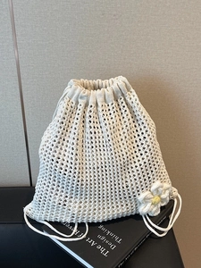 Mochila de paja tejida con cordón, diseño de punto calado y detalle de margarita