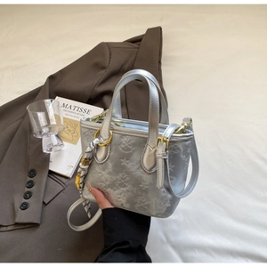 Detail of silver embossed bucket bag with star patterns and stylish silk scarf