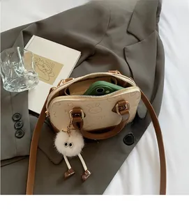 Detail view of the open crossbody shell bag showing internal capacity with a smartphone
