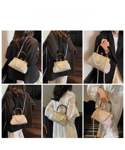 Detailansicht von Jacquard-Blumenmustern, Bambusgriff und Perlenkette an der Handtasche
