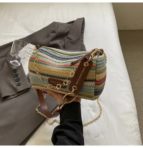 Detail of colorful woven cylinder bag with rainbow stripes and leather strap