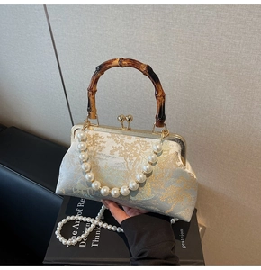 Detail der Vintage-Sticktasche mit Bambusgriff und eleganter Perlenketten-Schultergurt