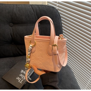 Pink embossed leather bucket bag featuring star patterns and black checkered silk scarf