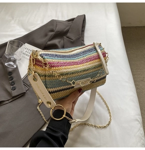 Close-up of rainbow striped straw bucket bag with gold chain and white logo strap