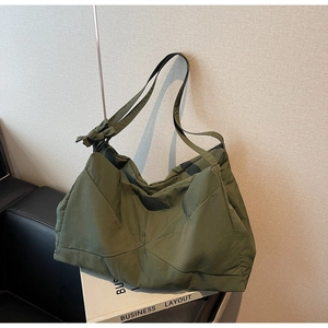 Close-up of olive green tote bag with triangular stitching and bow ribbon detail