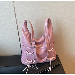 Close-up of pink ballet-style tote bag featuring white ribbon bow and silver buckle