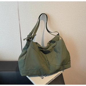 Detail of army green quilted tote bag with bow knot strap and glossy nylon fabric