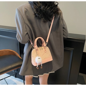 Pink mini shell bag with bear pattern, long strap and fluffy plush charm detail