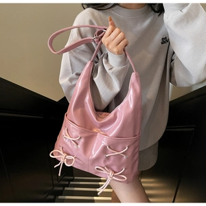 Detailed close-up of pink glossy tote bag with ribbon bow and crossover lace-up design