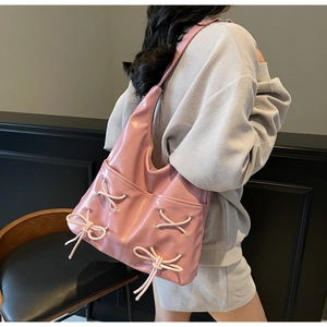 Pink bow bucket bag shown on shoulder, highlighting spacious PU leather side detail