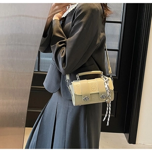 Close-up of beige crossbody bag with embossed cartoon rabbit and stylish top handle